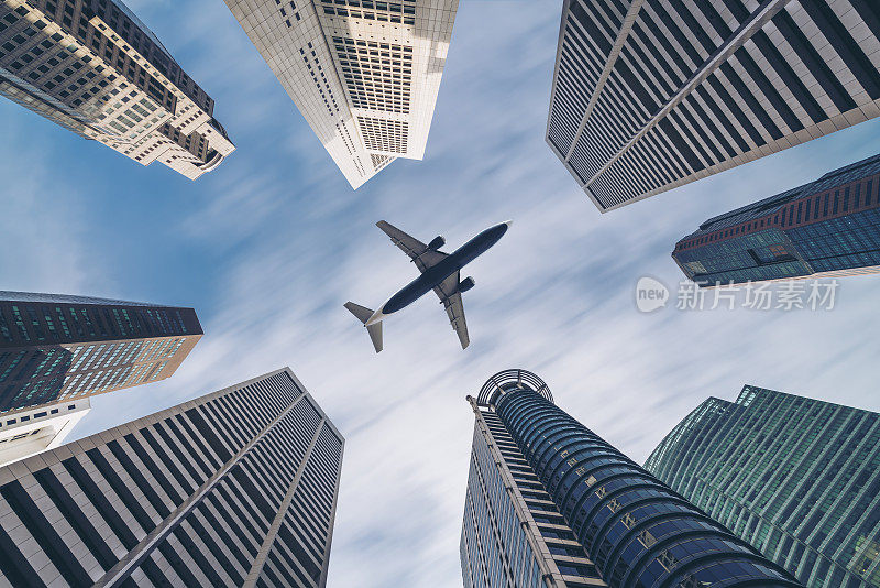 飞机飞过城市的商业大厦，高楼大厦