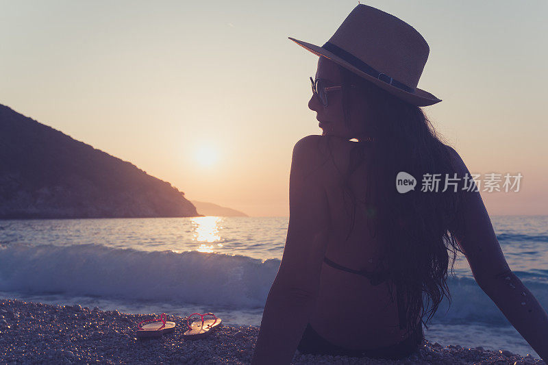 美丽的年轻女子，享受日落在著名的Myrtos海滩，凯法洛尼亚，希腊