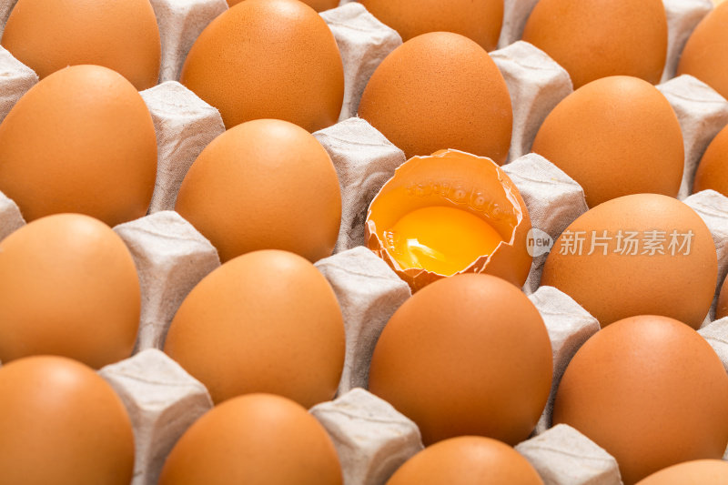 纸板托盘里装满了棕色的鸡蛋，其中一个鸡蛋破了