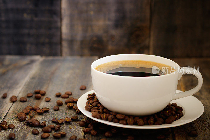 咖啡杯和咖啡豆放在木桌上