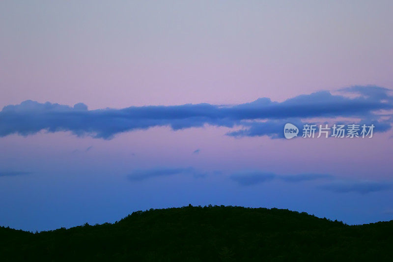 夜幕降临，森林上空蓝紫色的云