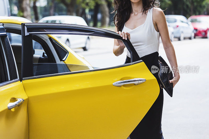漂亮的女商人上了一辆黄色出租车