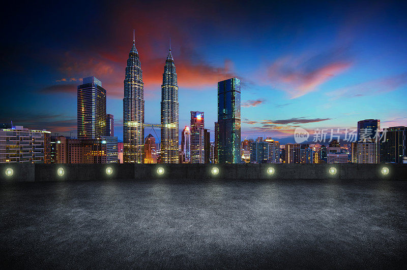 空的侧视图沥青停车场与吉隆坡城市天际线，夜景。