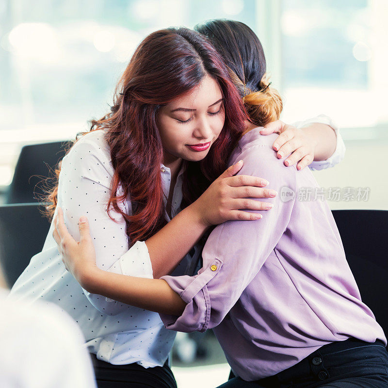 一个女人在互助小组会议上安慰朋友