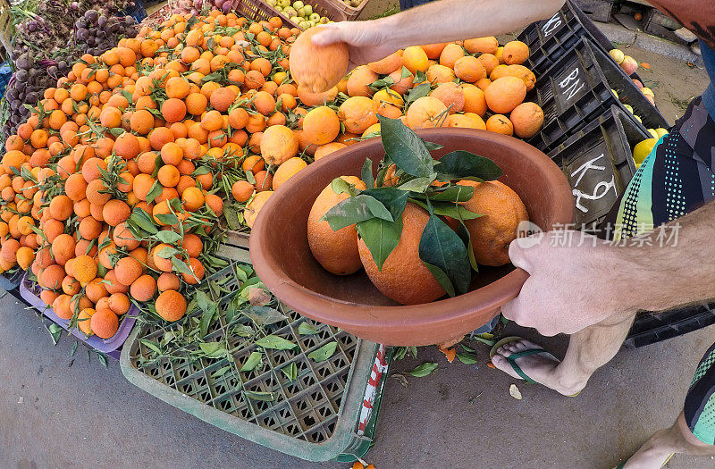 在摩洛哥的街头市场，一名男子在买橘子