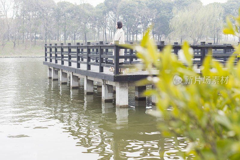 美丽的女人靠在栏杆上看风景