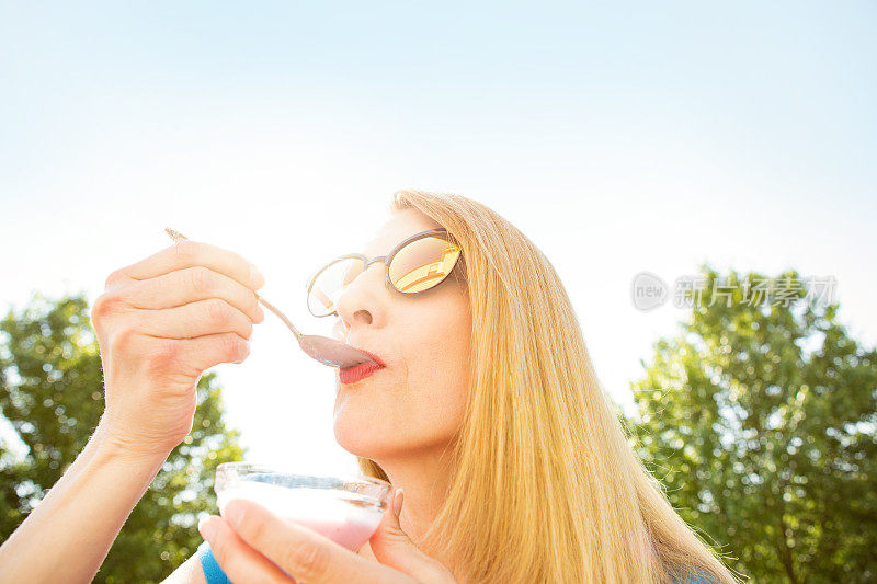 在户外吃酸奶的女人