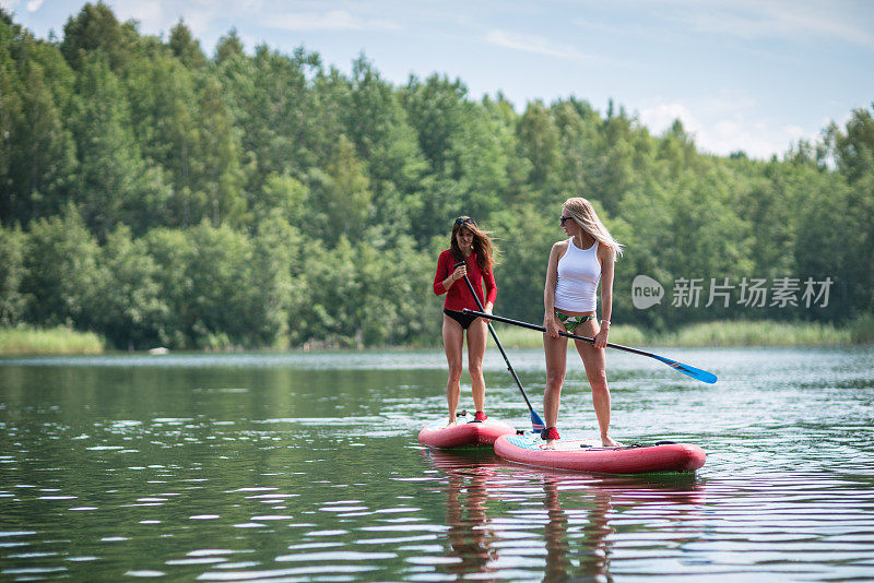 在湖岸附近用站立式桨板进行娱乐活动