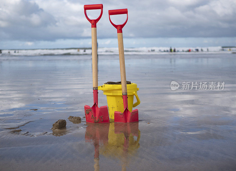 铲子和水桶放在海滩上