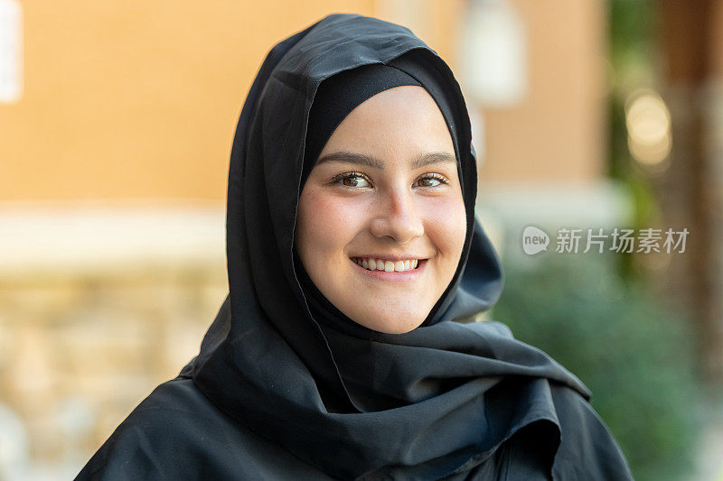 年轻的穆斯林妇女微笑着看着镜头