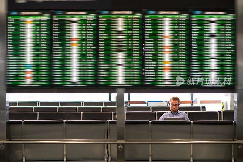 一名商人在等待登机时使用笔记本电脑工作