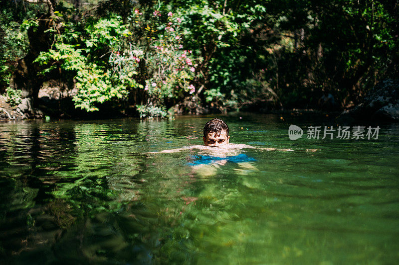 一个年轻人在河里游泳