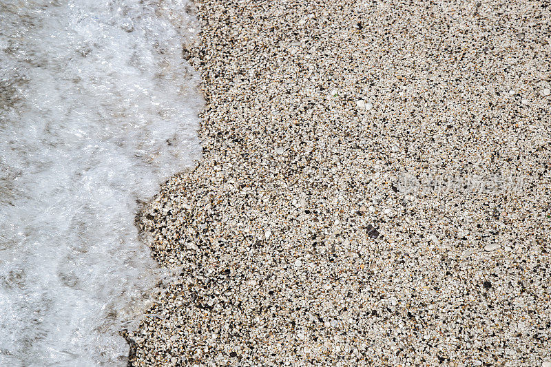 柔软的海浪拍打着沙砾海滩
