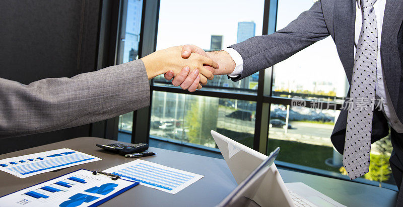 商务男士和商务女士在办公室开会时握手，成功，交易，问候和合作伙伴的概念。