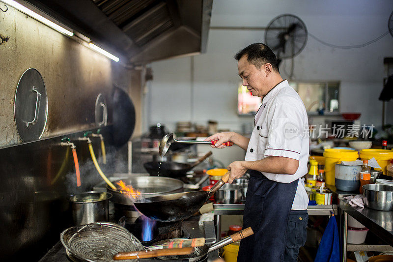 一位亚洲华人首领正在厨房里做饭