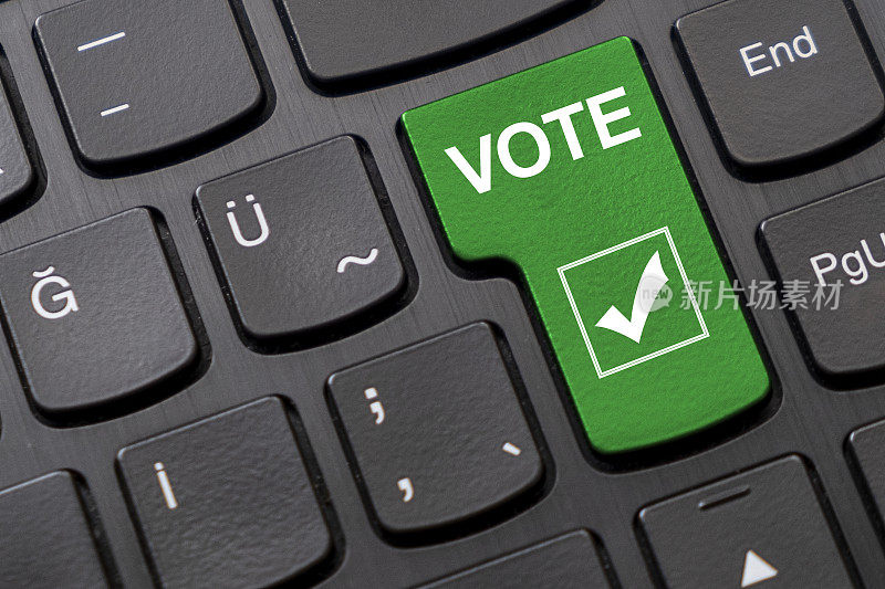 绿色的“投票”按钮，在黑色的电脑键盘上有一个勾号
