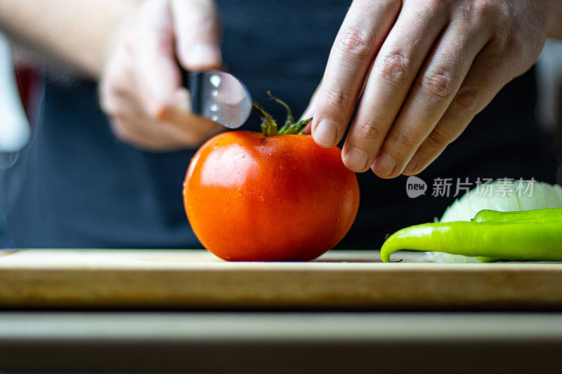 男厨师正在砧板上切西红柿