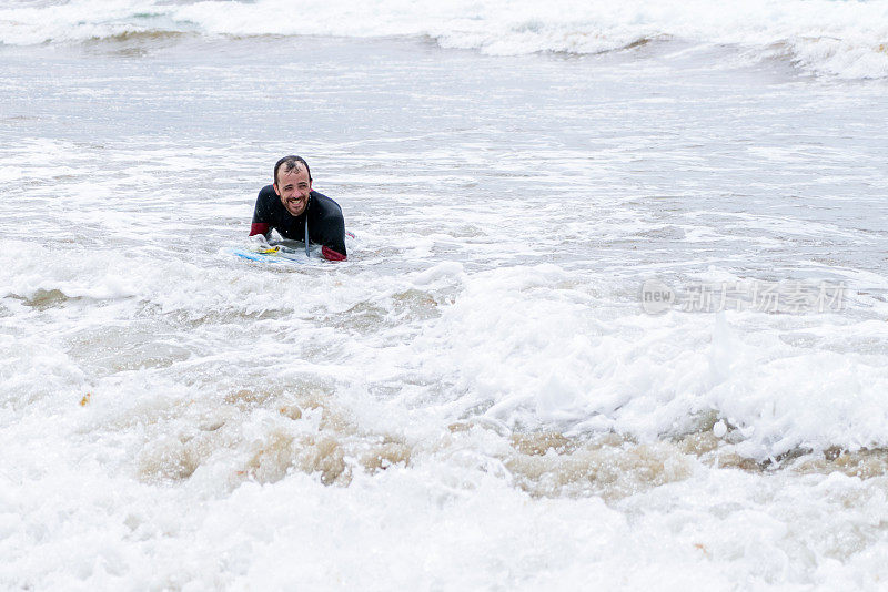 成年男性喜欢在冲浪海滩上玩人体滑板