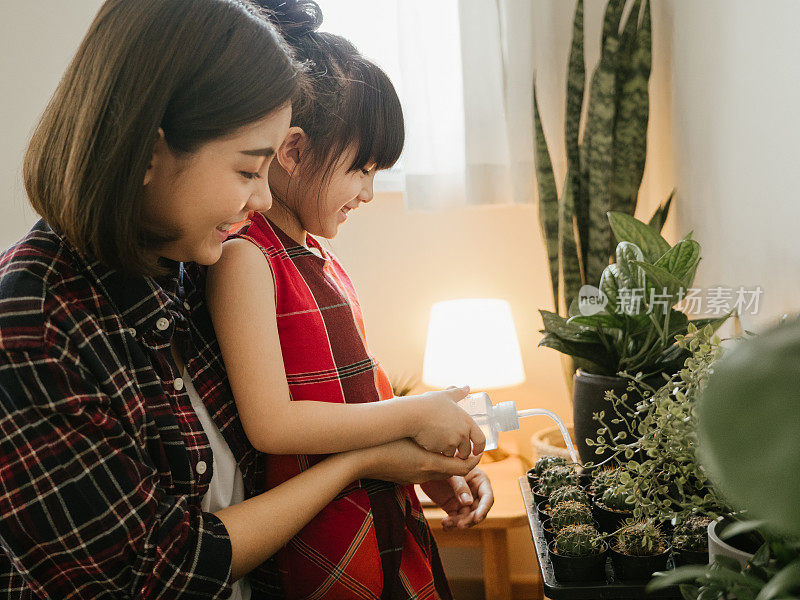 时髦的母亲和女儿照顾植物