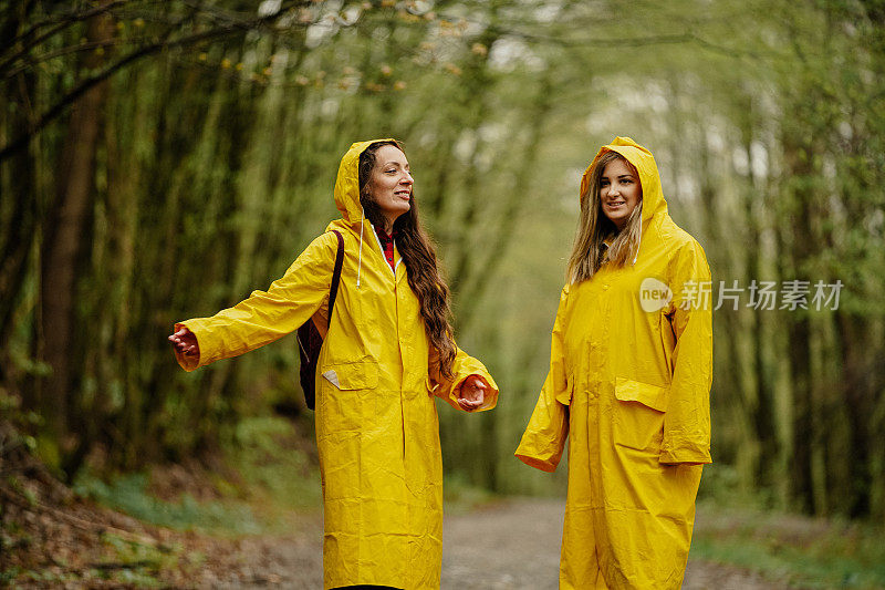 两个穿着黄色雨衣的年轻女子在雨中