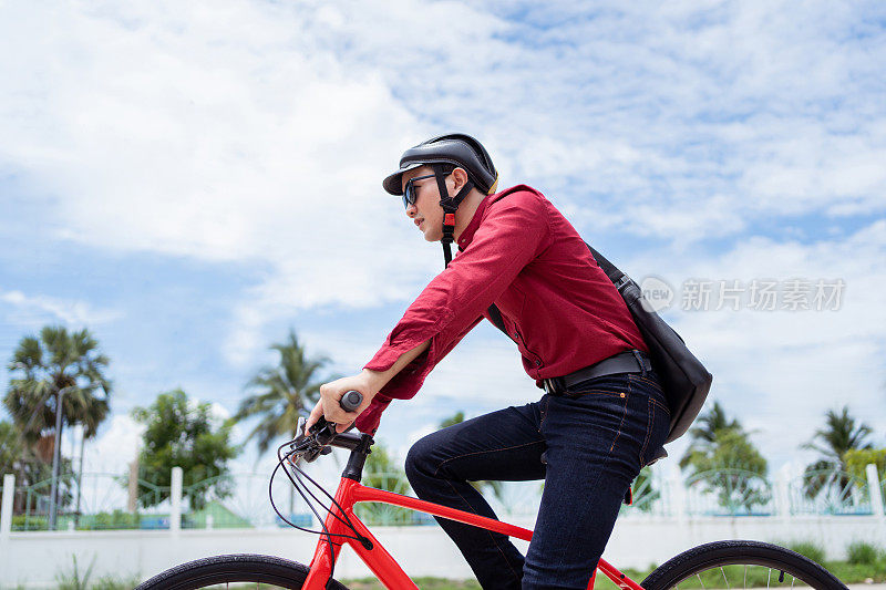 一名亚洲男子早上骑自行车去上班。
