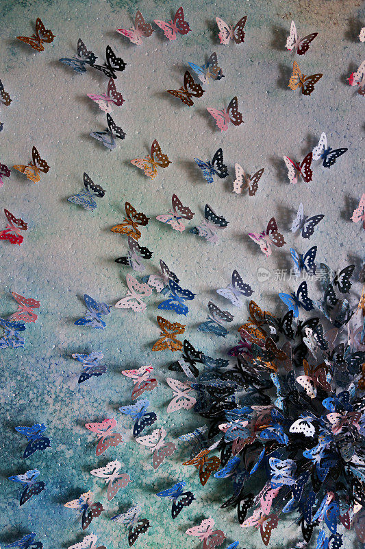 原工艺美术作品的图像裁剪出五彩缤纷的蝴蝶形状(帝王蝶-紫色，蓝色，橙色，粉红色和黑色的颜色)，彩色的艺术和工艺项目显示在墙上作为背景墙纸