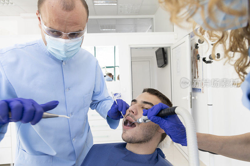 近距离拍摄专业牙医戴着防护口罩为病人做检查