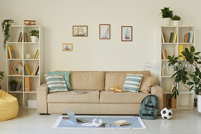 室内舒适的客厅与孩子的东西和船照片上面的沙发，房子的设计理念