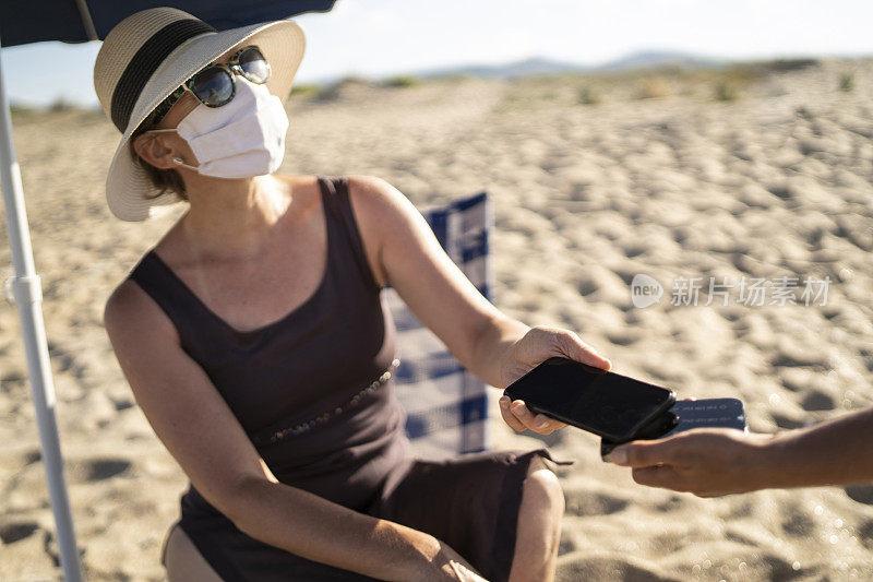 2019冠状病毒病假期:女性在暑假期间用智能手机刷卡
