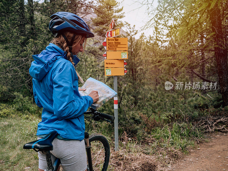 山地自行车手在路标前停下来