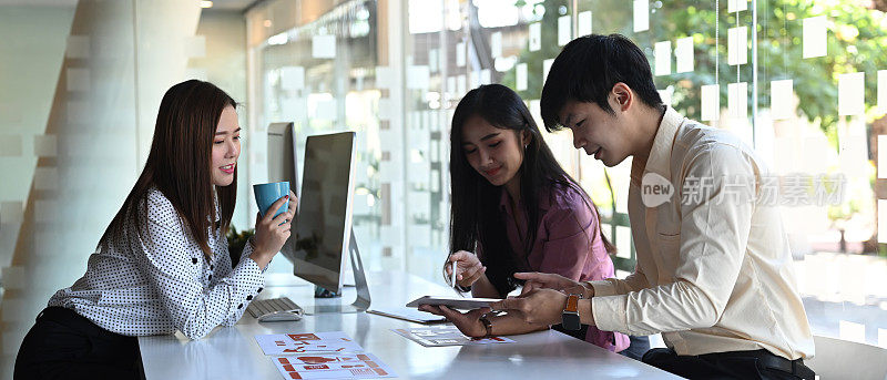 这是一群年轻的亚洲用户体验开发人员和用户界面设计师在会议室开发手机应用程序的照片。