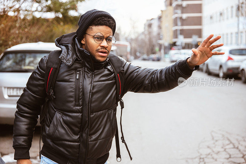 年轻的非裔美国人在街上等优步或出租车