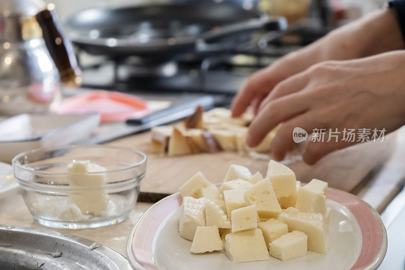 女人在准备早餐，切尔克斯奶酪和羊乳酪在盘子里