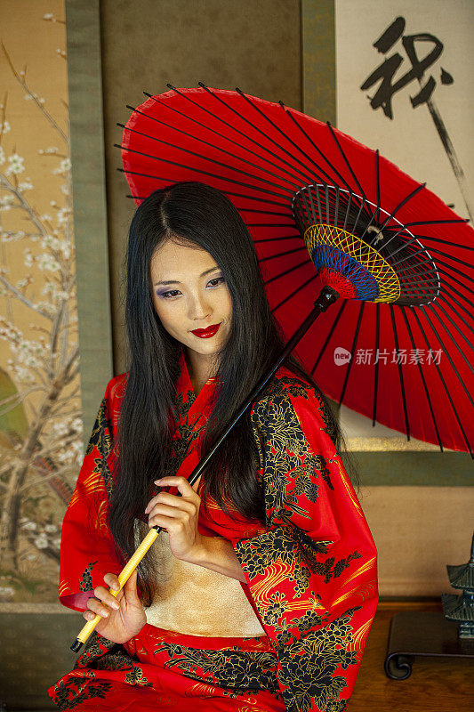 穿着和服和红伞的美丽日本女人