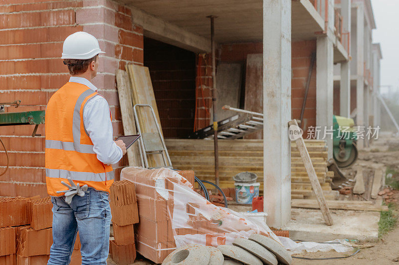 男性建筑师在建筑工地使用数字平板电脑