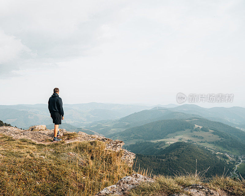 徒步旅行者在长满草的山脊上放松的观点