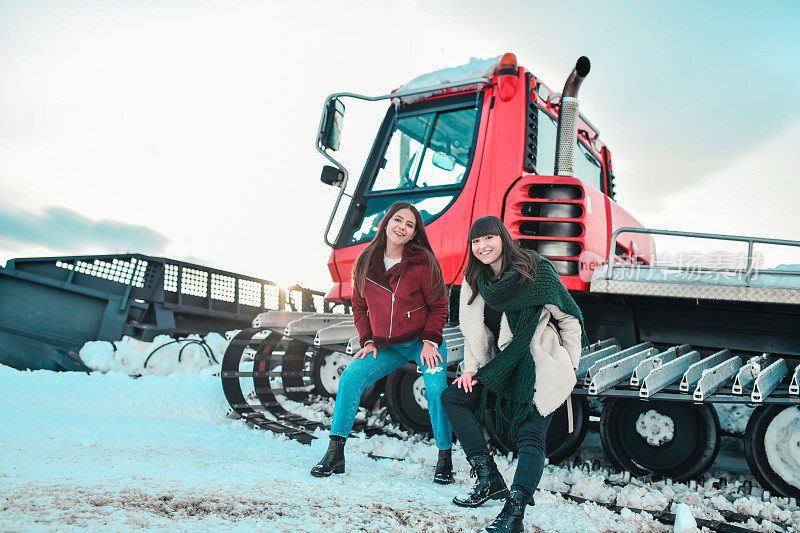 女性享受坐在除雪车在冬季山区假期