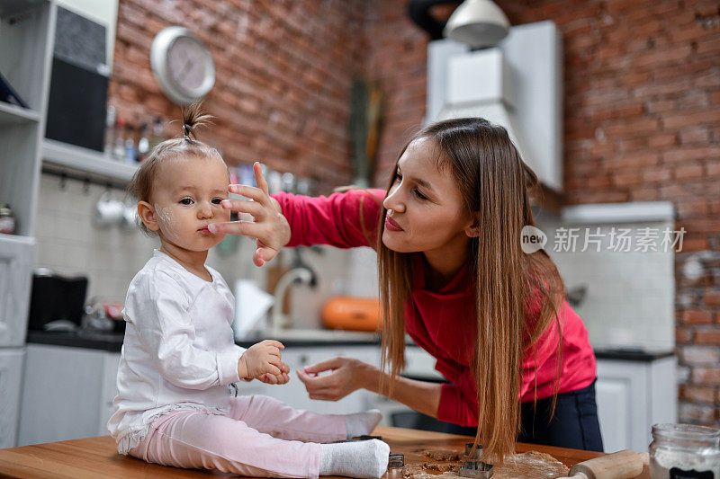 妈妈在厨房做蛋糕的时候和女儿玩