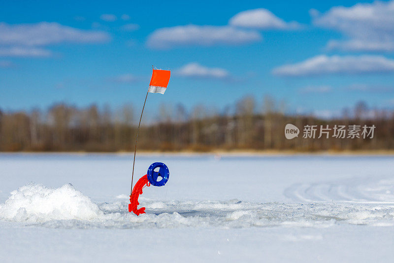 钓具在冰面上用一个有拷贝空间的红旗发出鱼咬人的信号。