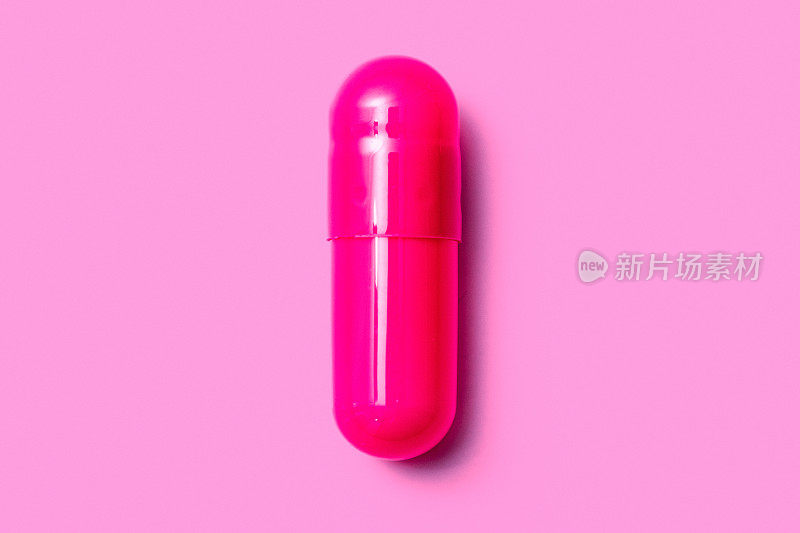 通用的粉红色明胶药丸在粉红色的背景