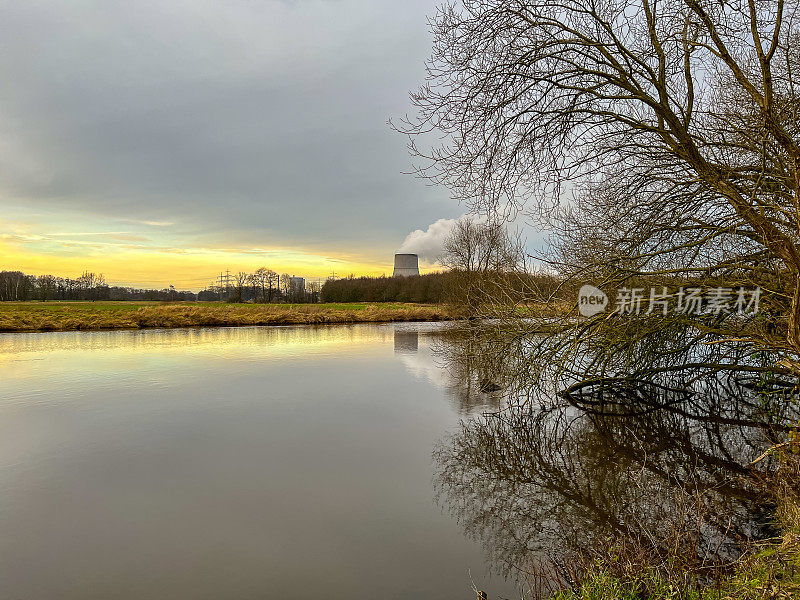 这条名为“Ems”的河在冬天的傍晚，背景是一座核电站。