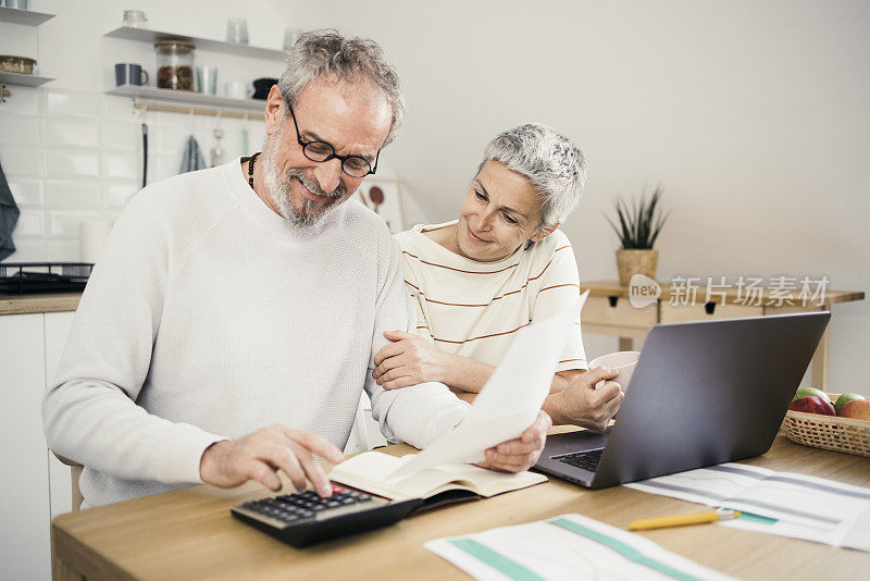 快乐的老男人和他的妻子计算他们的每月收入和开支