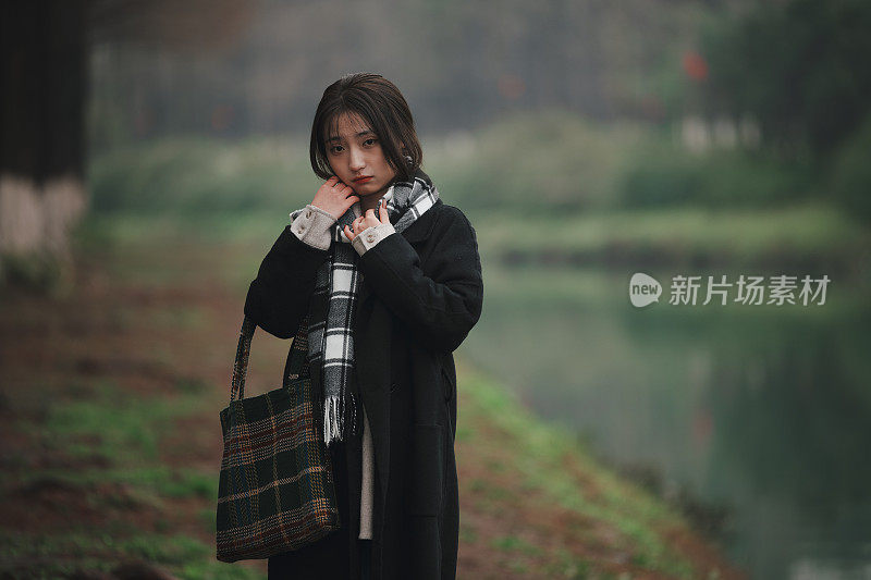 亚洲女孩走在河边的雨天