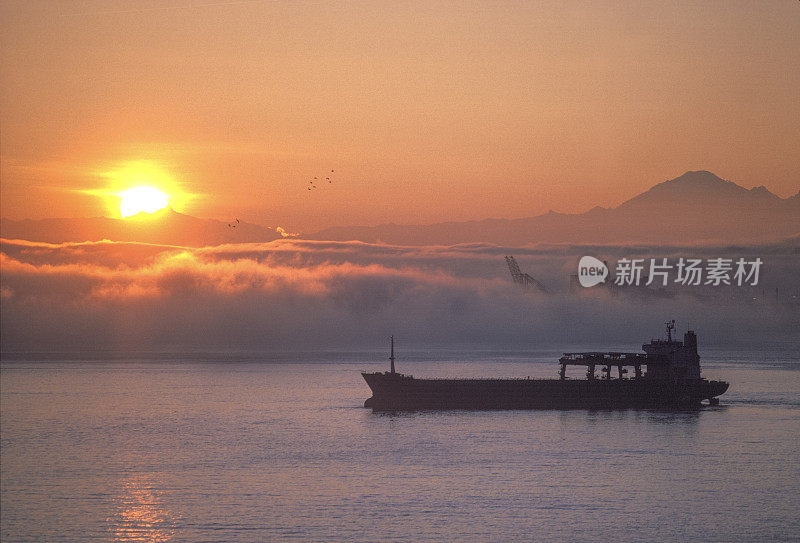 日落时货船巡航的高架视图