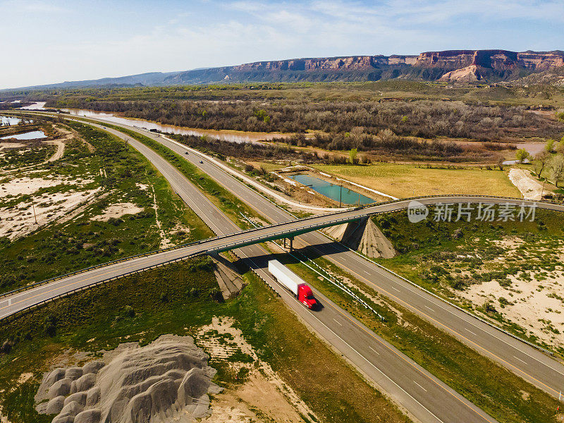 在美国西部70号州际公路和立交桥上驾驶的车辆和半卡车的无人机视图