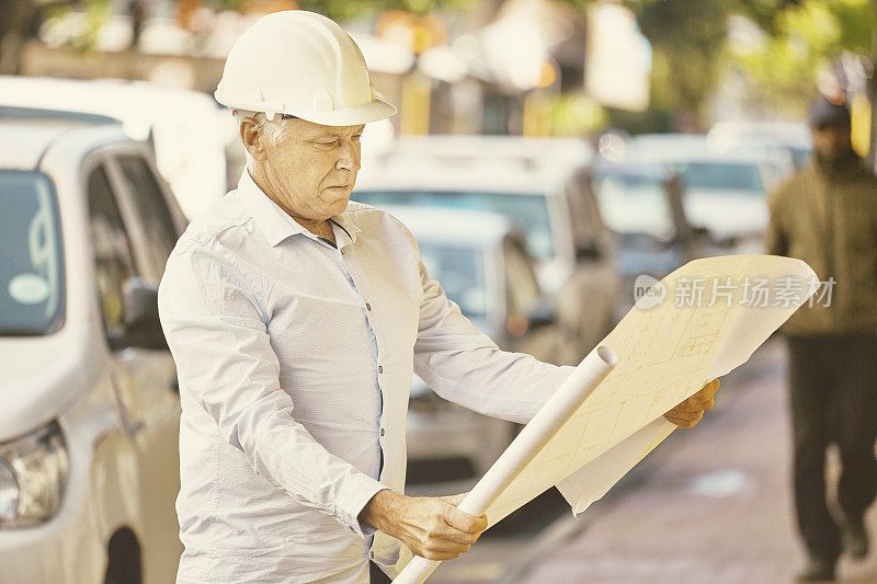 带着白色安全帽和建筑规划的建筑经理