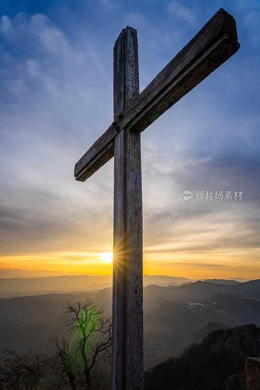 近距离观看宗教十字架在山顶上日落