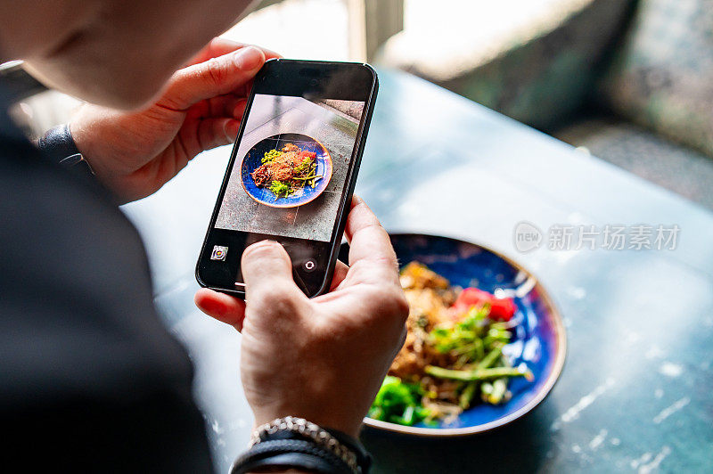 用智能手机在餐厅或咖啡馆拍摄食物