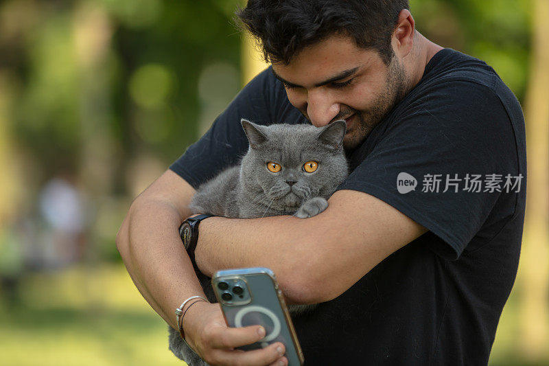 年轻英俊的男子正在和他的猫自拍。