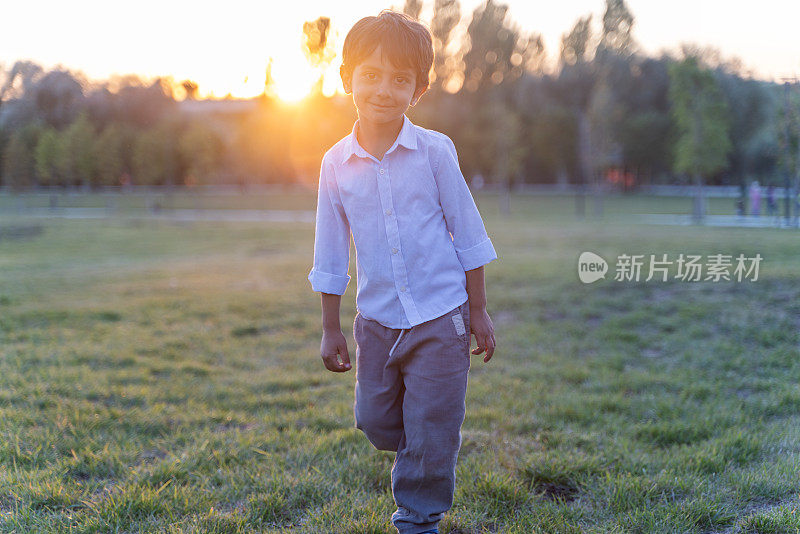 夕阳下，男孩在草地上奔跑